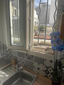 d'une cuisine avec évier et d'une fenêtre avec vue. dans l'établissement Trendy 2 Rooms Paris 13, à Paris