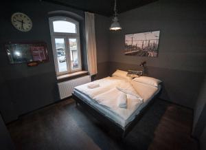 1 dormitorio con 1 cama y reloj en la pared en Hostel am Bahnhof, en Suhl