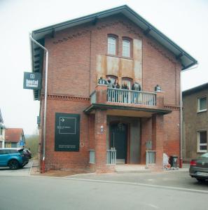 a group of people on the balcony of a brick building at Hostel am Bahnhof in Suhl