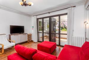 a living room with a red couch and a tv at Apartments with parking space Pjescana Uvala, Pula - 7349 in Pula