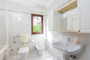 a white bathroom with a toilet and a sink at Apartments with parking space Pjescana Uvala, Pula - 7349 in Pula +20 photos
