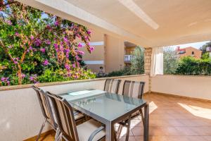 a table and chairs on a balcony with flowers at Apartments with parking space Pjescana Uvala, Pula - 7349 in Pula