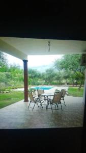 a patio with a table and chairs and a pool at Confortable casa traslasierra. Vista al Champaqui in Quebrada de los Pozos