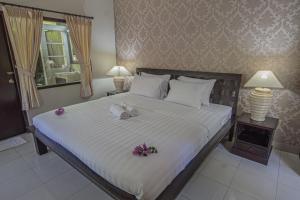 a bedroom with a large bed with flowers on it at Panorama Cottages I in Legian