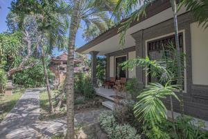 a house with palm trees in front of it at Panorama Cottages I in Legian
