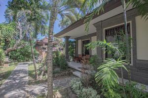 ein Haus mit Palmen davor in der Unterkunft Panorama Cottages I in Legian