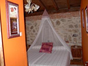 a bed with a canopy in a room at Casa Rural Pincherres in Mata de Quintanar