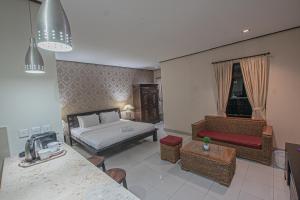 a living room with a bed and a couch at Panorama Cottages I in Legian