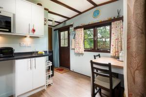 a kitchen with a table and a dining room at Low Tarn Lodge in Elterwater