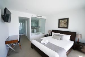 a bedroom with a bed and a desk and a television at Oracle-Awesome Ocean Views in Gold Coast