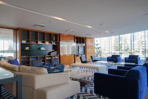 una stanza con sedie e tavoli e una stanza con finestre di Oracle Broadbeach - Amazing Ocean Views! a Gold Coast