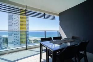 una sala da pranzo con tavolo e sedie e una grande finestra di Oracle Broadbeach - Amazing Ocean Views! a Gold Coast