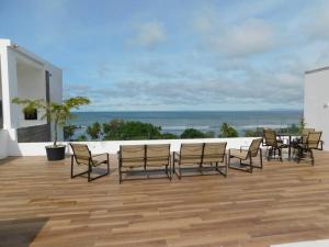 Un grupo de sillas y una mesa en un patio. en Sunset 205, sleeps six, next door to the pool, 100m to the beach!, en Jacó