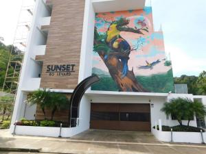 Un edificio con un mural en el costado. en Sunset 205, sleeps six, next door to the pool, 100m to the beach!, en Jacó