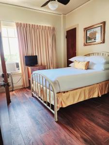 a bedroom with a large bed and a television at The Faust Hotel in New Braunfels