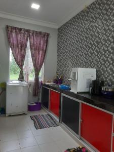 a kitchen with a counter top with a microwave at Nor Su Homestay in Kampong Alor Gajah