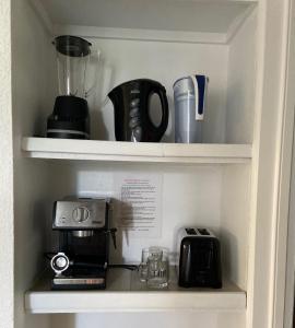 a shelf with a coffee maker and a blender at Mermaid's Lighthouse in West Palm Beach