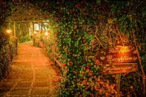 a sign in a garden with a bunch of plants at Hotel Ponta do Madeiro in Pipa