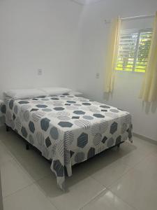 a bed with a black and white comforter in a room at Lotus Antunes Beach in Antunes