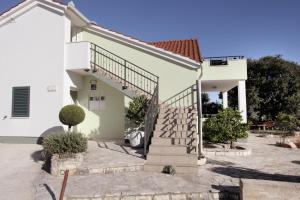 a house with a staircase in front of it at Apartments with a parking space Okrug Gornji, Ciovo - 19713 in Trogir