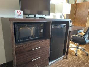telewizor na drewnianej szafce z kuchenką mikrofalową w obiekcie Super 8 by Wyndham Ketchikan w mieście Ketchikan