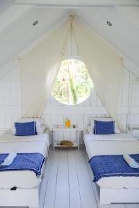 two beds in a room with a tent at Soultribe Beach Retreat in General Luna