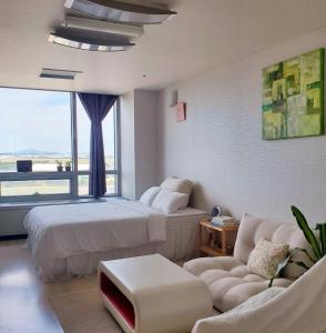 pokój hotelowy z łóżkiem i kanapą w obiekcie Cozy - Good Vibes Studio w mieście Inczon