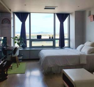 a bedroom with a large bed and a large window at Cozy - Good Vibes Studio in Incheon
