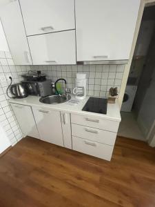 a small kitchen with white cabinets and a sink at Apartment Deluxe IM in Medulin