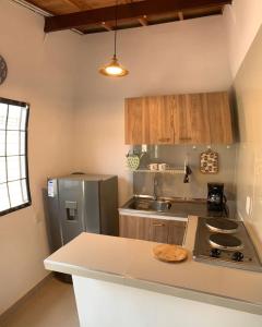Il comprend une cuisine équipée d'un réfrigérateur et d'un comptoir. dans l'établissement Casa campestre los cerezos, à Santa Marta
