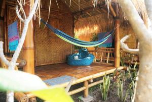 a hammock in a hut with a table and chairs at SAME SAME Bungalows by The Spot in Kuta Lombok +15 photos