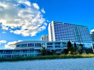 um edifício ao lado de uma massa de água em Castle Beach Resort Condo Penthouse or 1BR Direct Ocean View -just remodeled- em Miami Beach