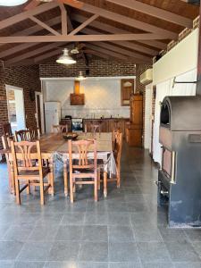 cocina y comedor con mesa de madera y sillas en Los abuelos en San Antonio de Areco