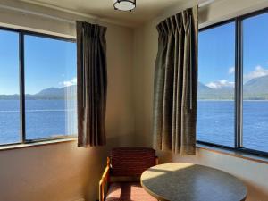 a room with large windows with a table and chairs at Super 8 by Wyndham Ketchikan in Ketchikan