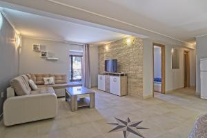 a living room with a couch and a table at Apartments by the sea Veli Losinj, Losinj - 19782 in Veli Lošinj