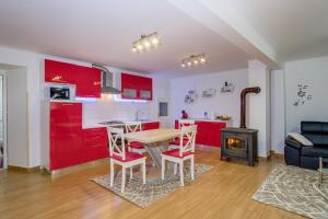 a kitchen with red cabinets and a table and chairs at Apartments by the sea Veli Losinj, Losinj - 19782 in Veli Lošinj