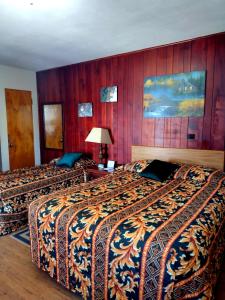 2 camas en una habitación de hotel con paredes de madera en The King's Inn, en Sidney