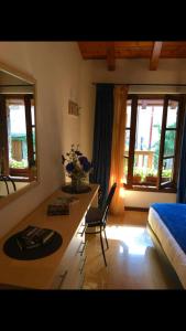um quarto com uma mesa, uma cama e janelas em Splendido cottage Lakeview em Bellagio
