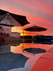 una piscina con dos sombrillas en el agua al atardecer en Bargara Blue Resort, en Bargara