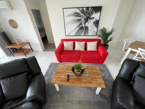 a living room with a red couch and a coffee table at Bargara Blue Resort in Bargara