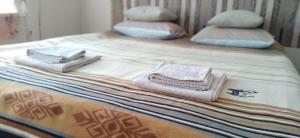 een bed met handdoeken en kussens erop bij Уютный ночлег Иссыкские курганы in Rakhat