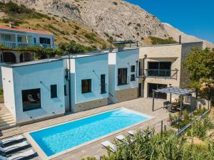 een huis met een zwembad ervoor bij Luxury villa with a swimming pool Bosana, Pag - 19824 in Pag