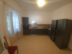duża kuchnia z czarnymi urządzeniami i białymi szafkami w obiekcie Apartments by the sea Cove Vela Stiniva, Hvar - 19895 w mieście Zastražišće +13 zdjęć