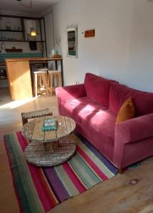 ein Wohnzimmer mit einem rosa Sofa und einem Tisch in der Unterkunft El Trotamundos in Puerto Pirámides