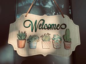 a wooden sign that says welcome with cactuses at Hải An Homestay - Garden by the Beach in Phan Rang