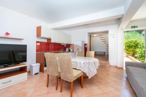 a kitchen and dining room with a table and chairs at Apartments by the sea Tkon, Pasman - 19913 in Tkon