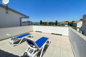 a pair of lounge chairs on the roof of a house at Apartments by the sea Tkon, Pasman - 19913 in Tkon