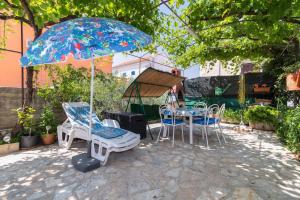 a patio with a table and chairs and an umbrella at Apartments by the sea Punat, Krk - 19831 in Punat
