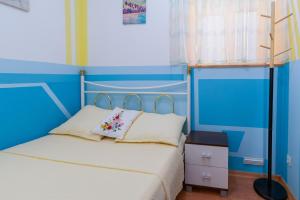 a blue bedroom with a bed with a cross on it at Apartments by the sea Punat, Krk - 19831 in Punat