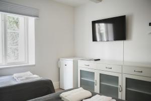 a bedroom with two beds and a tv on the wall at Mullbärsgårdens Rooms, Apartments & Villas in Visby